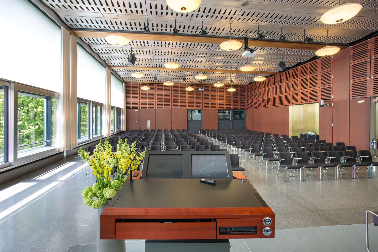 Rows of chairs and lectern in bright and airy conference room.